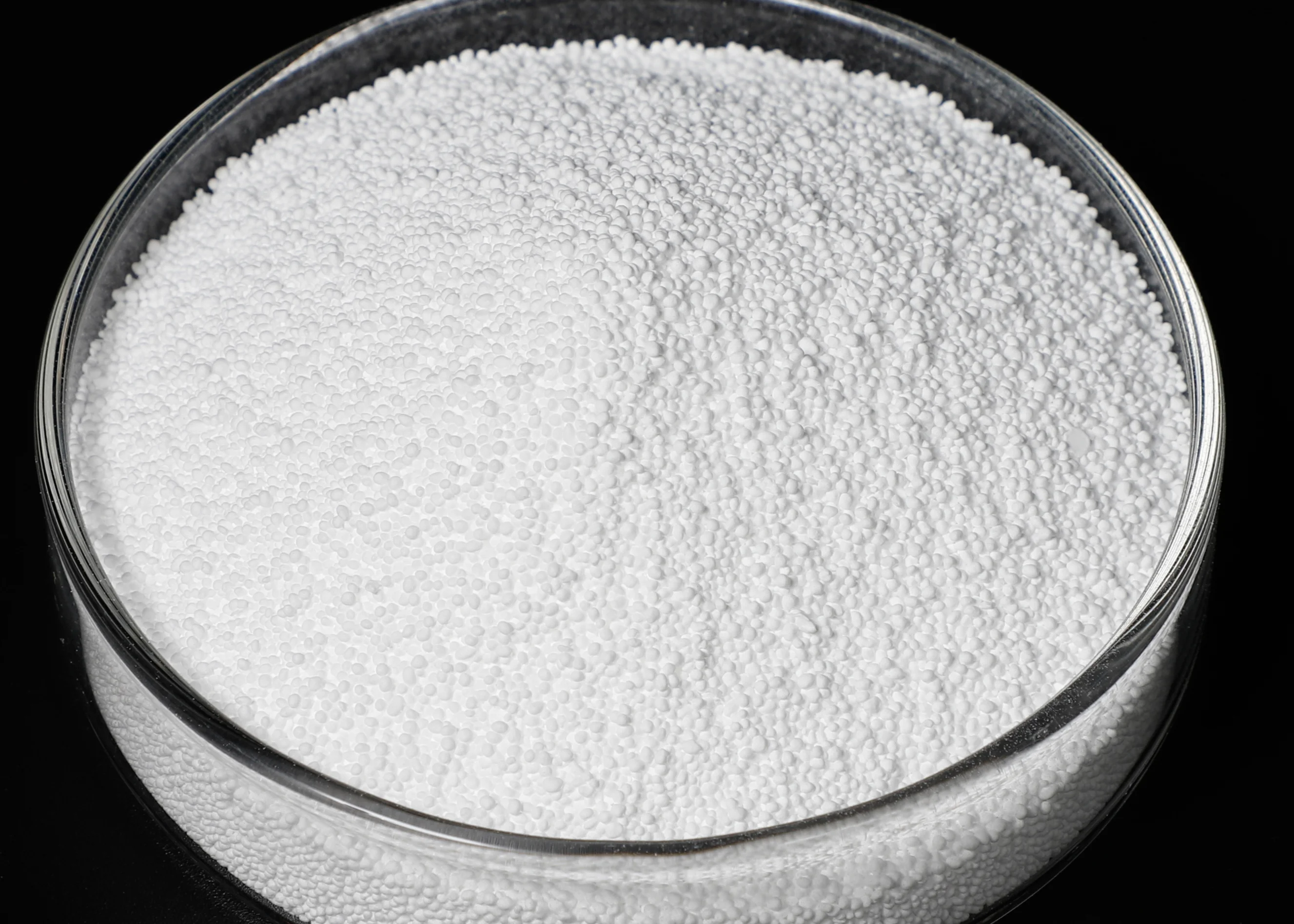 Partículas granulares uniformes de PTFE blanco con fina textura esférica llenan un recipiente transparente. - CANGZHOU QUANSHENGFU NEW MATERIALS CO.,LTD. | Cpsemarketplace