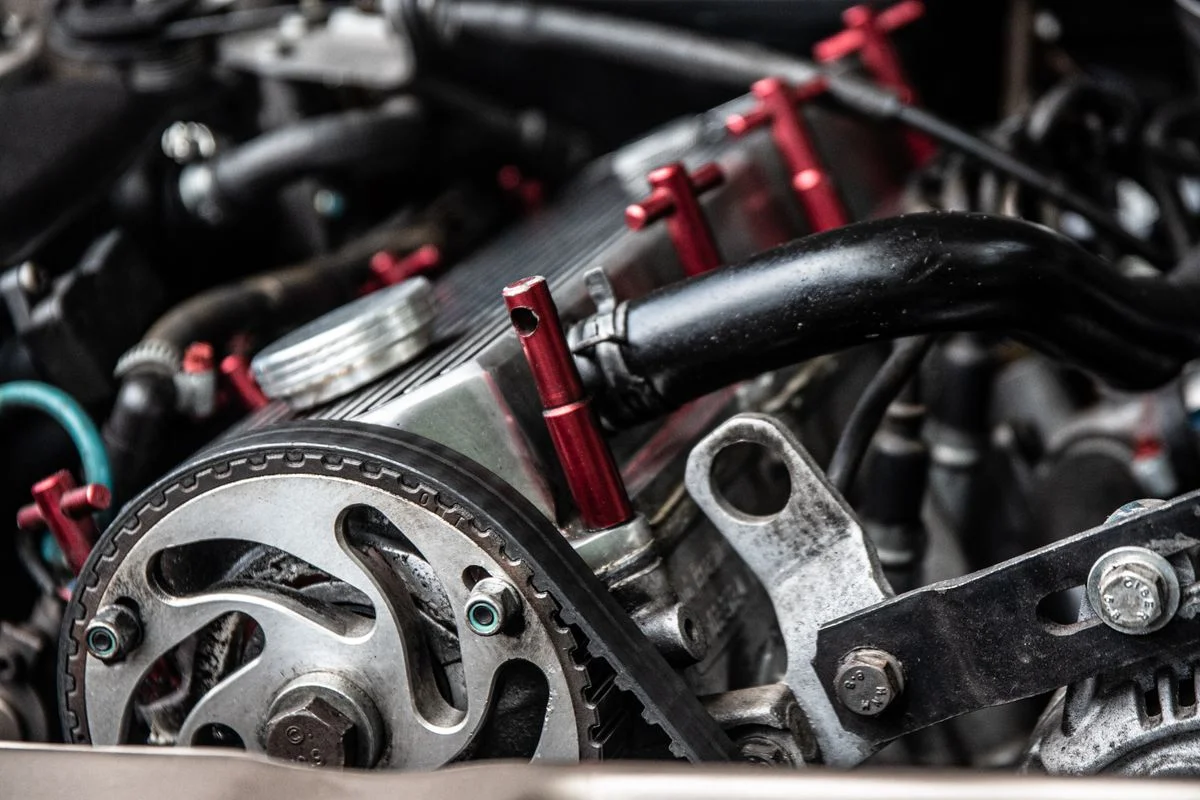 Correa de distribución de goma negra acoplada con poleas y tensores mecanizados con precisión para motores automotrices. - Pexels

