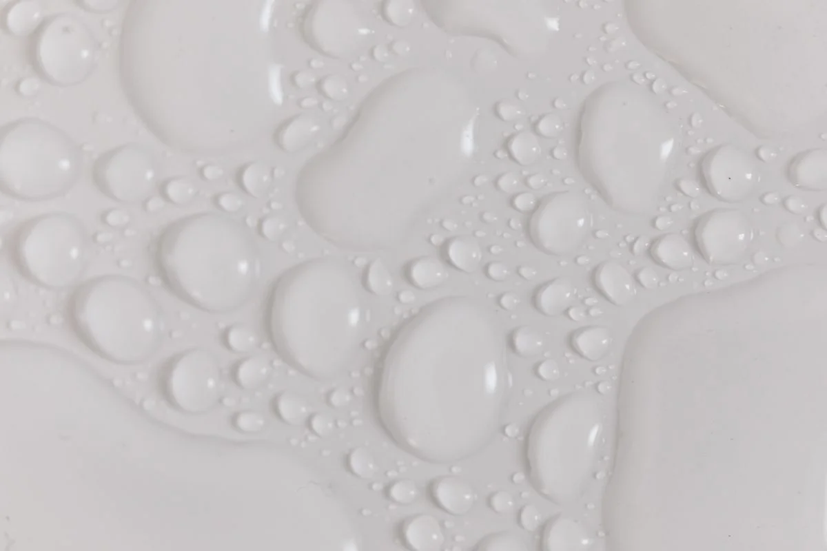 Viscous liquid silicone rubber droplets coalescing on a smooth surface for precision LSR molding applications. - Pexels