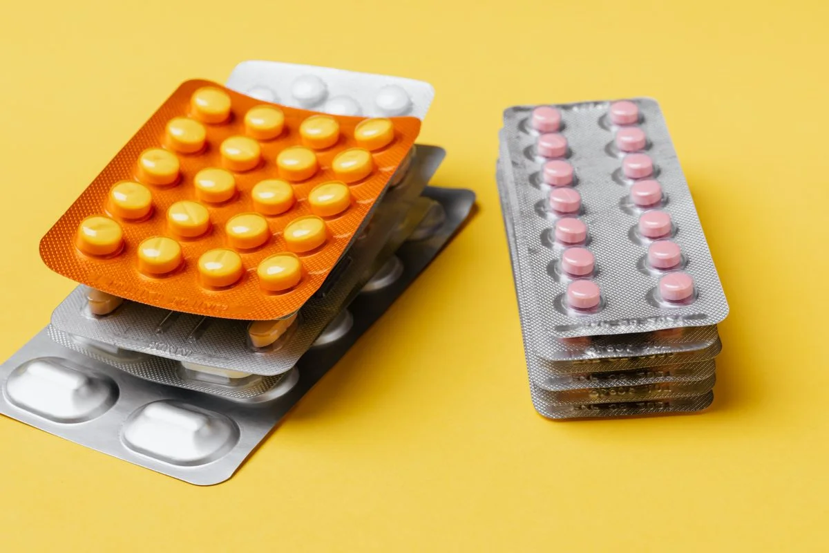 Thermoformed plastic blister packs containing yellow tablets and white capsules - Pexels

