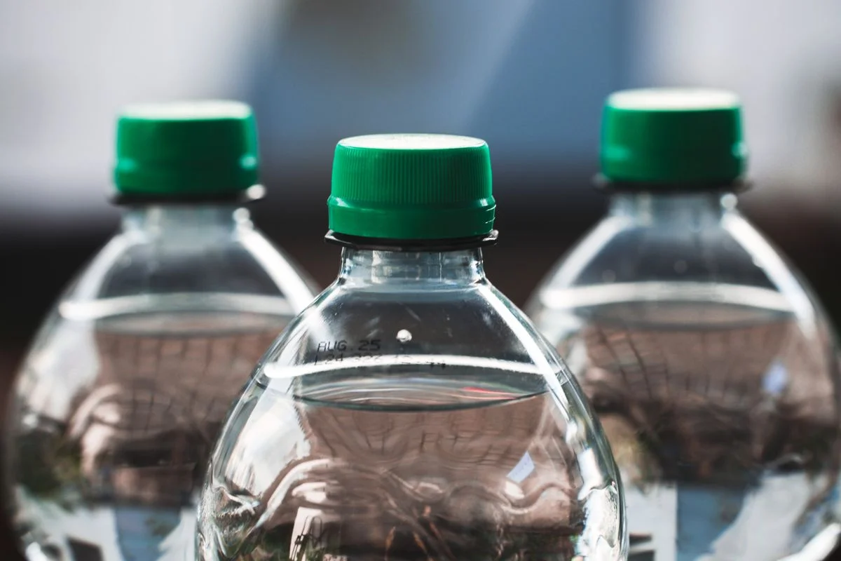 緑色のスクリューキャップと精密成形された首部と肩部を備えた透明なプラスチックボトル。 - Pexels

