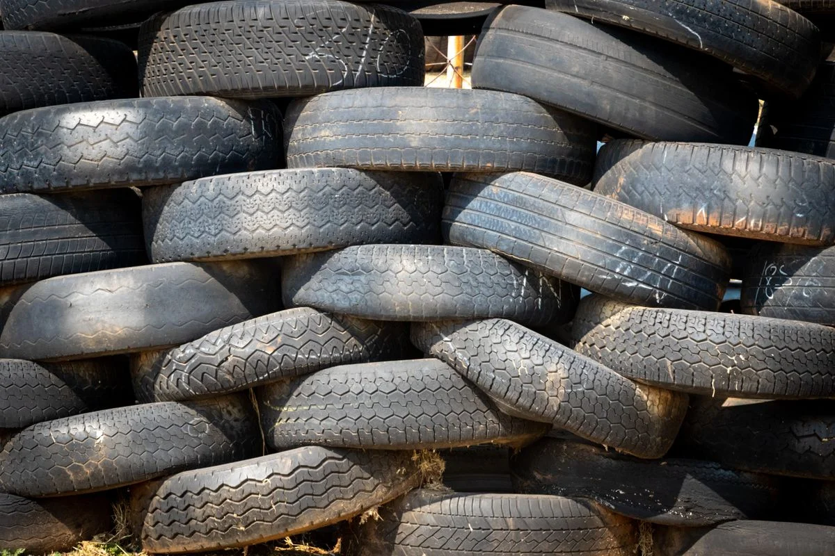 Stacked black rubber tires displaying detailed tread patterns and durable surfaces. - Pexels

