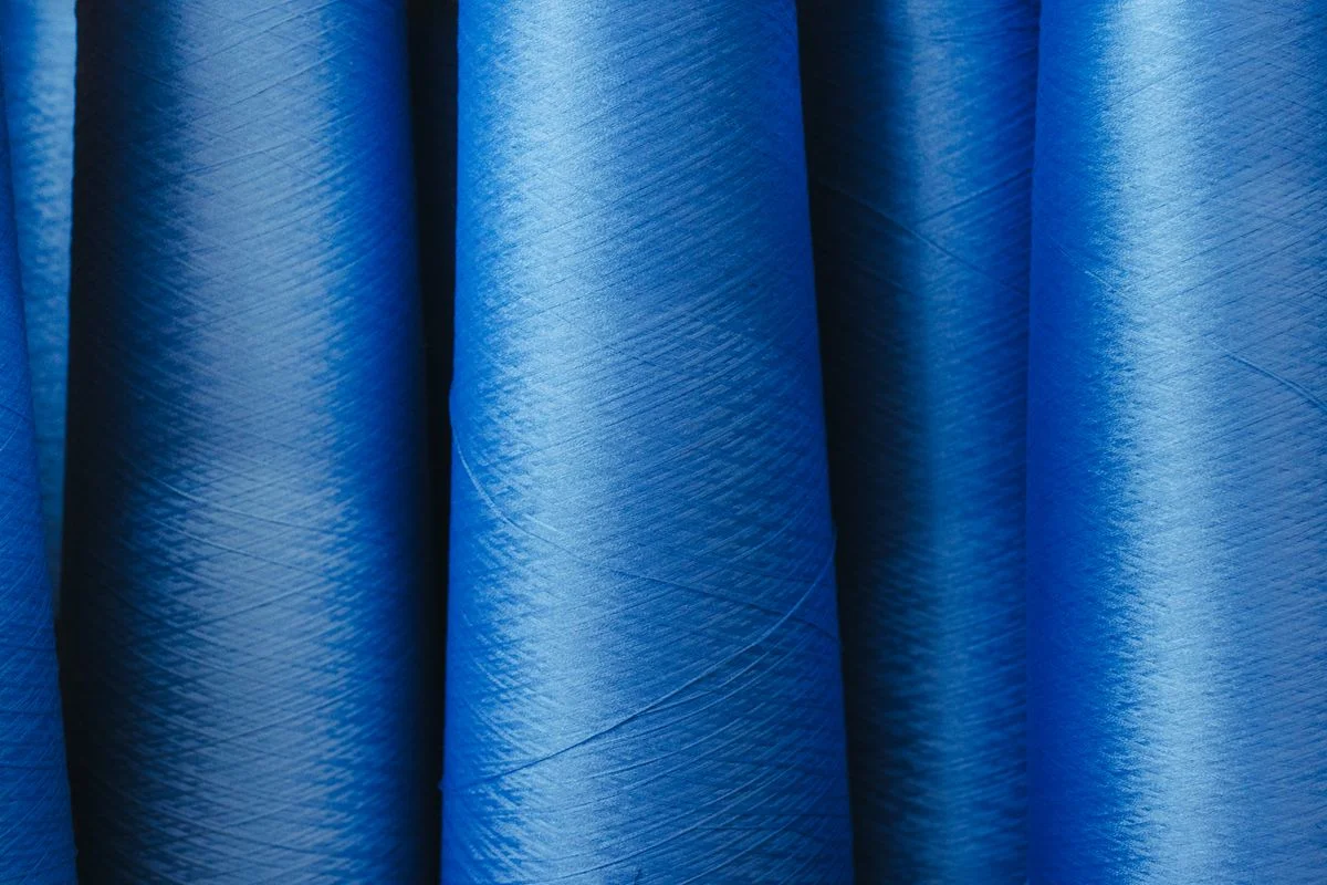 Blue synthetic filament yarn spools with uniform continuous fibers from melt spinning polymer processing - Pexels

