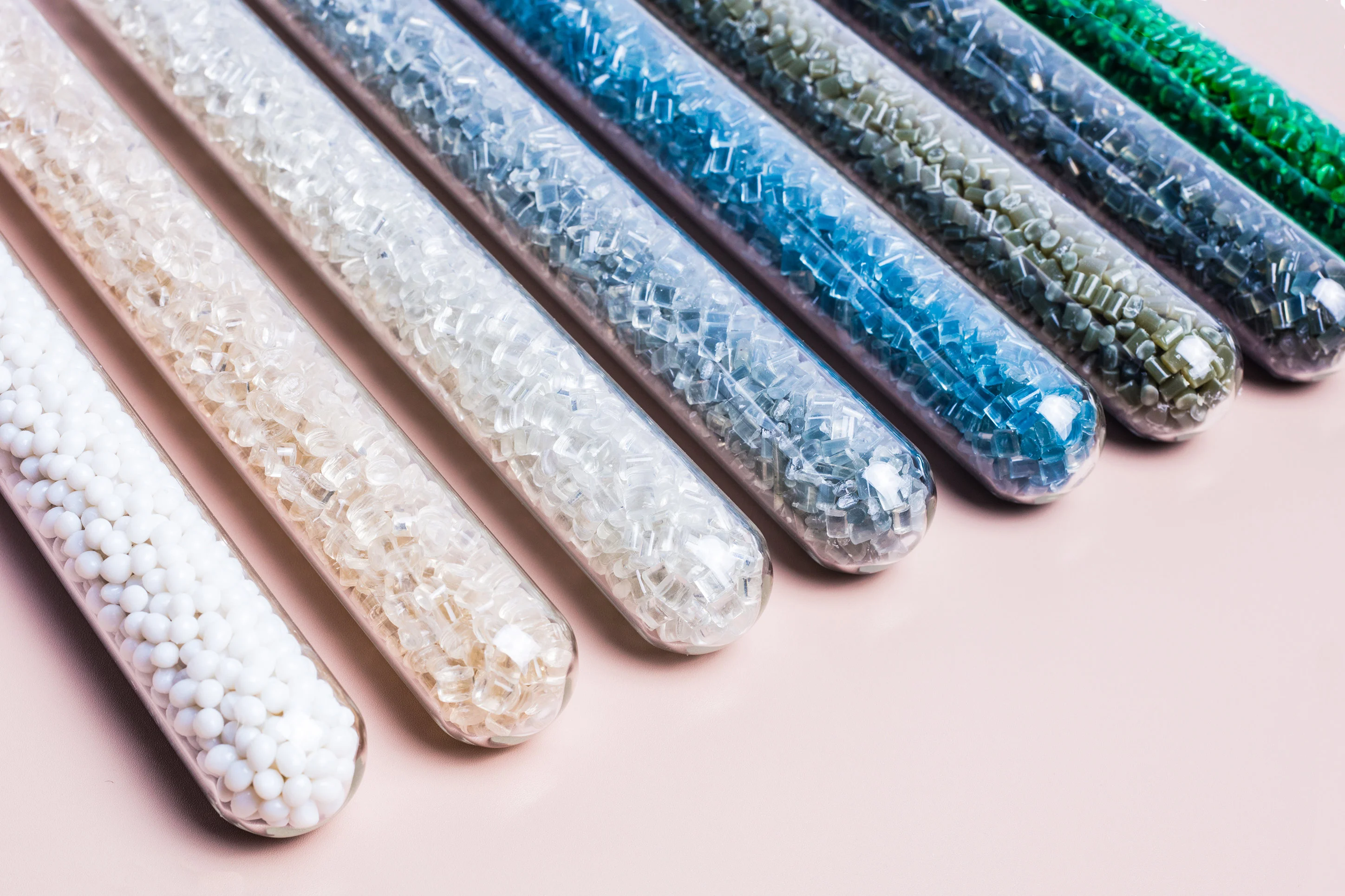 加工用のさまざまなプラスチックペレットが入った試験管が、多様なポリマーの種類と顆粒形状を示しています - INTCO RECYCLING | Cpsemarketplace

