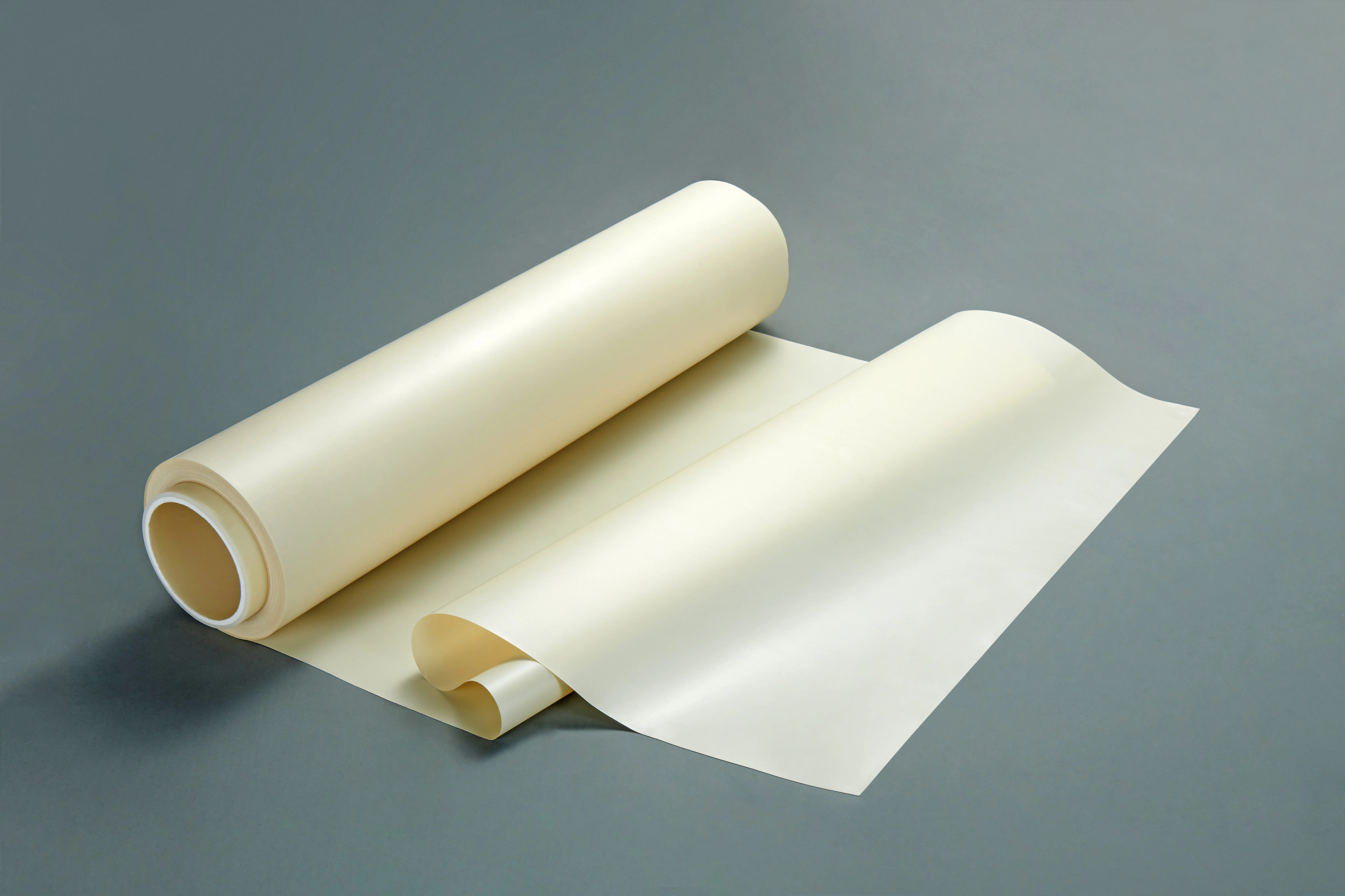 Neatly rolled spool of pale LCP polymer film partially unrolled, showing smooth texture and uniform quality. - NINGBO JUJIA NEW MATERIAL TECHNOLOGY CO.,LTD. | Cpsemarketplace

