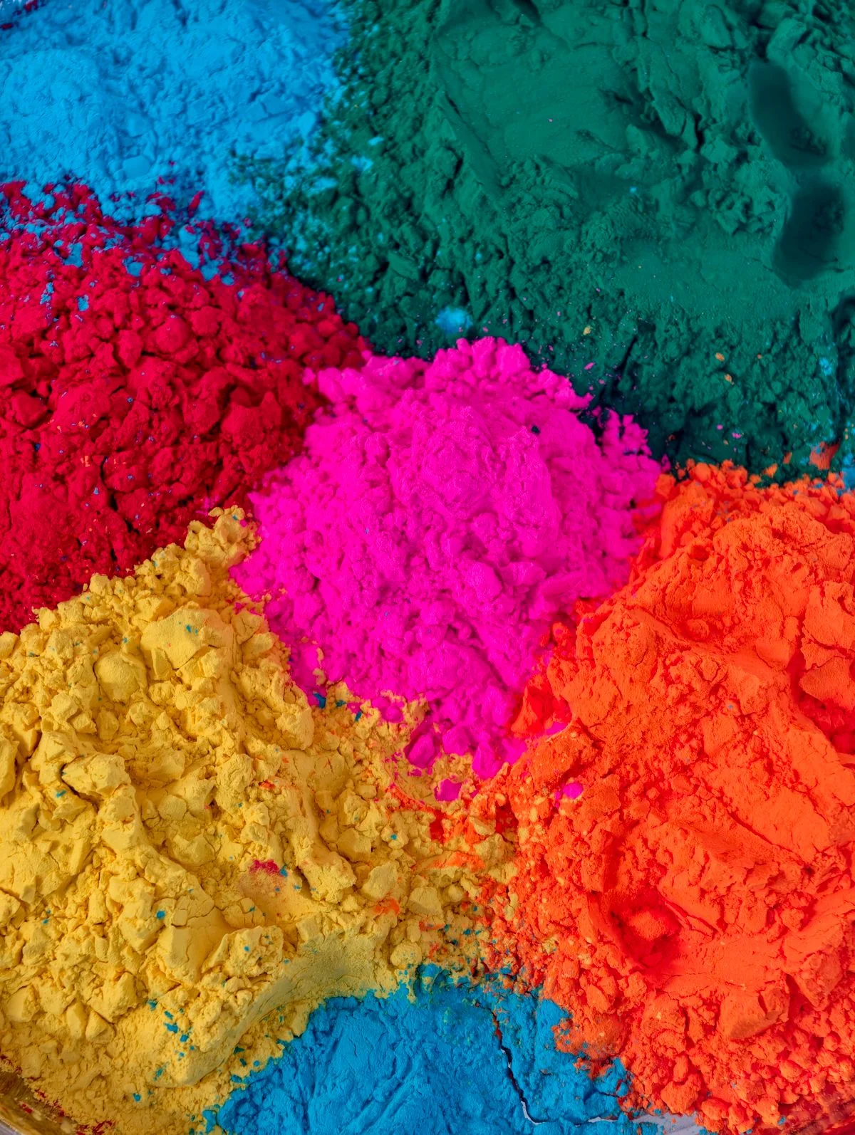 Poudres pigmentaires vibrantes rouges, jaunes, roses, bleues, vertes et oranges en piles distinctes pour applications plastiques. - Pexels