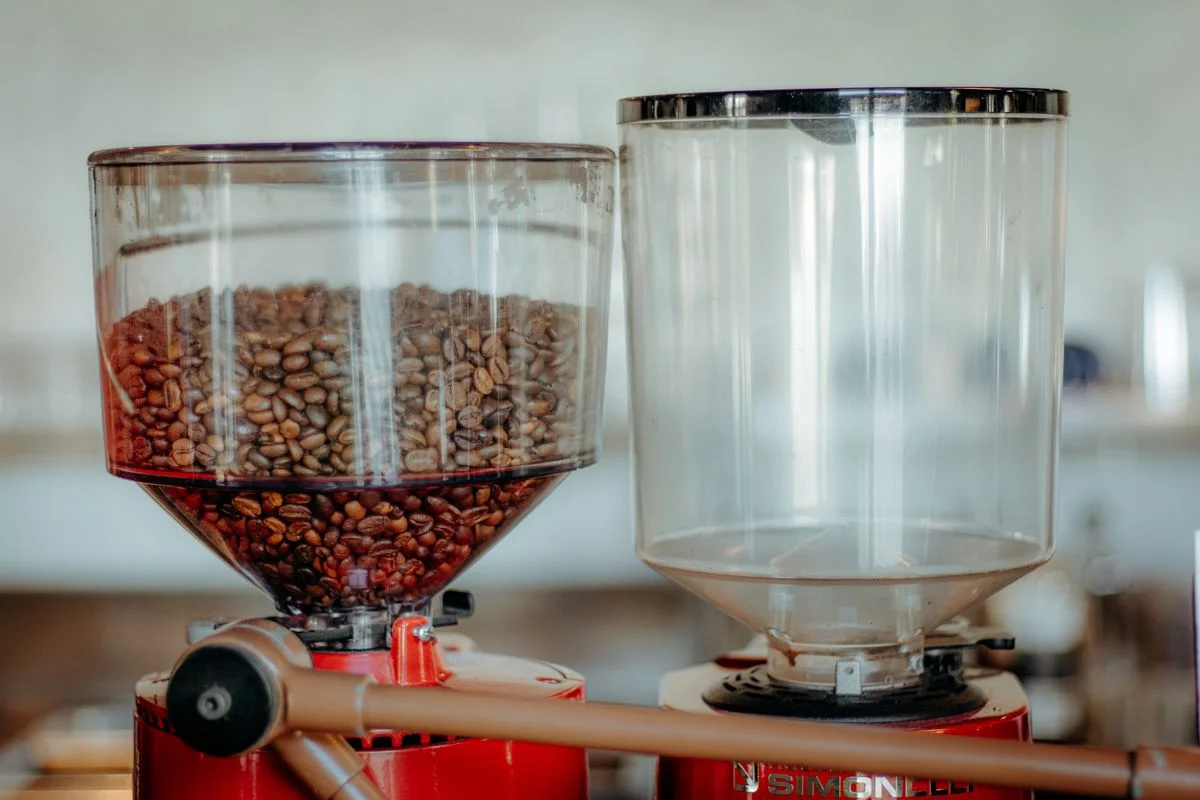 Molinillo de café comercial con tolva de metal pulido y recipiente transparente para granos. - Pexels