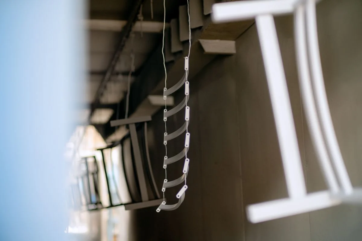 Componentes de polímero curvos blancos suspendidos de cables aéreos para tratamiento de superficie. - Pexels

